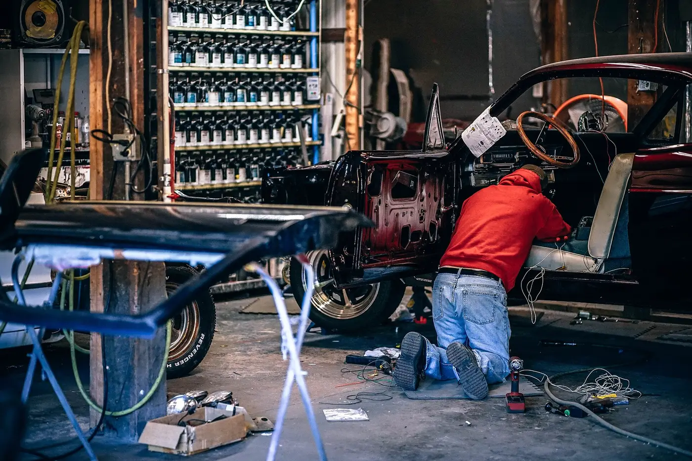 Mechanik podczas naprawy auta w hali warsztatu Maxauto
